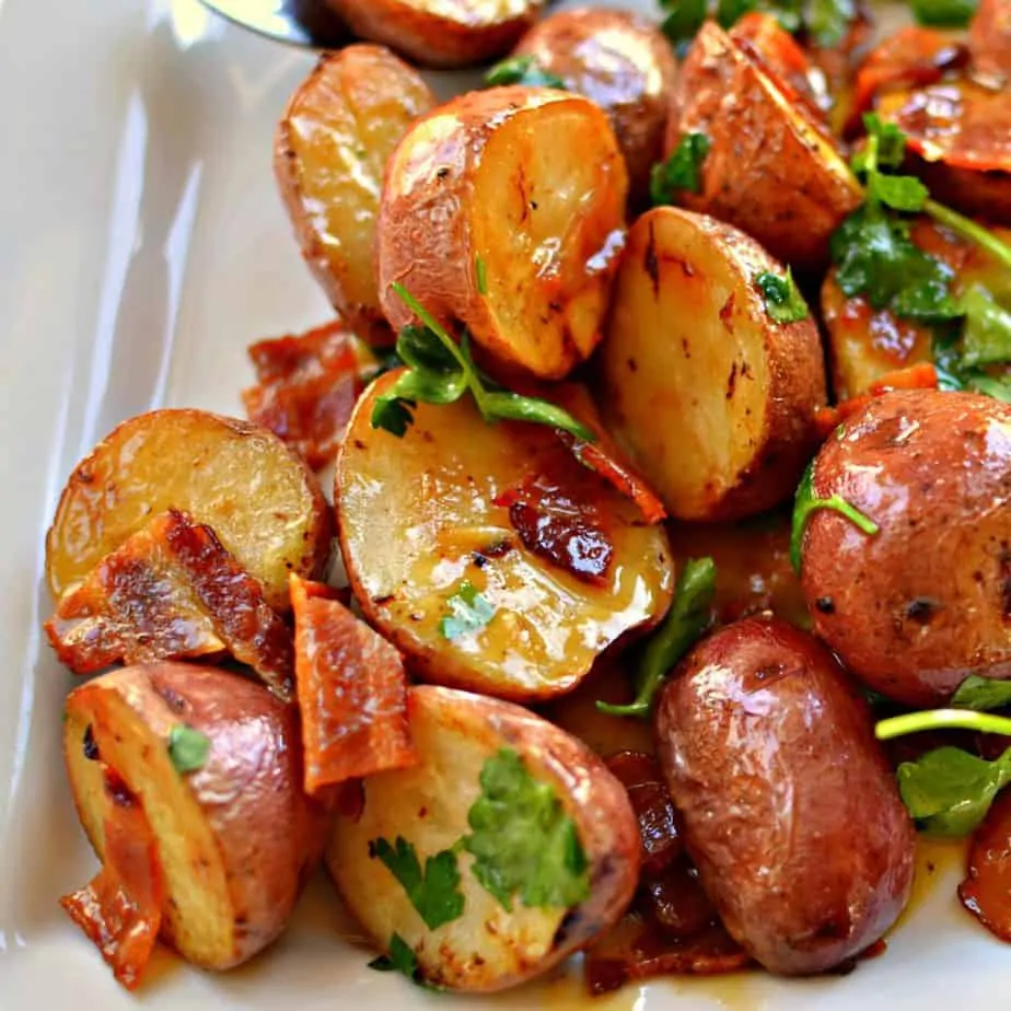 Warm honey mustard potato salad with fresh parsley on a large serving plate. 