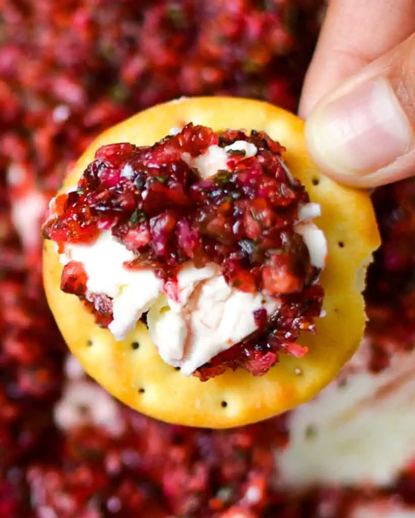 Cranberry salsa on top of cream cheese on a cracker. 