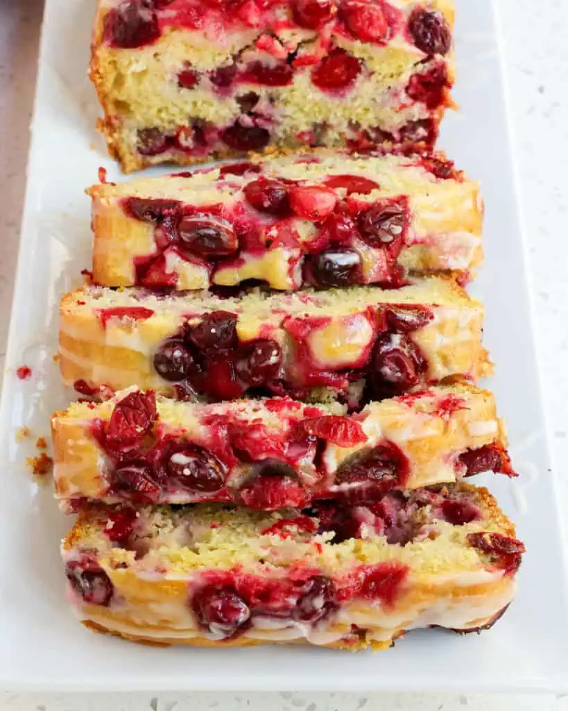 Slices of orange cranberry bread on a platter. 