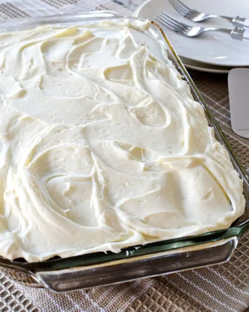 An overhead view of gingerbread cake with cream cheese frosting. 