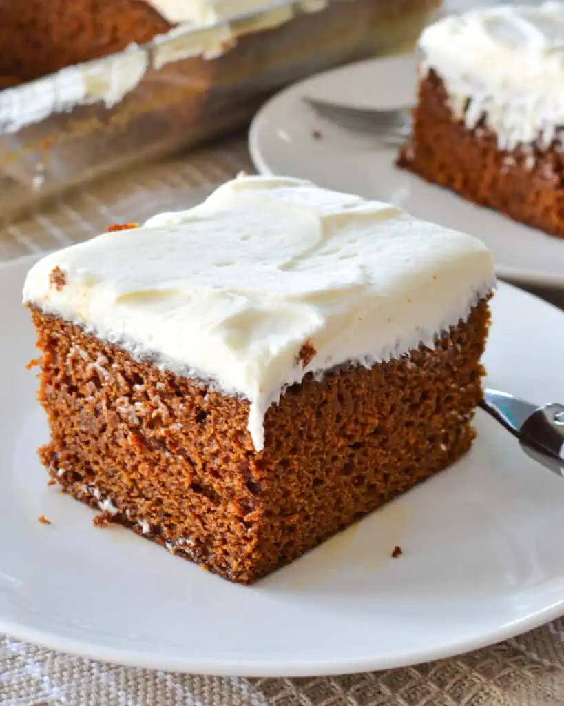 A slice of gingerbread cake on a singloe serving plate with a fork. 