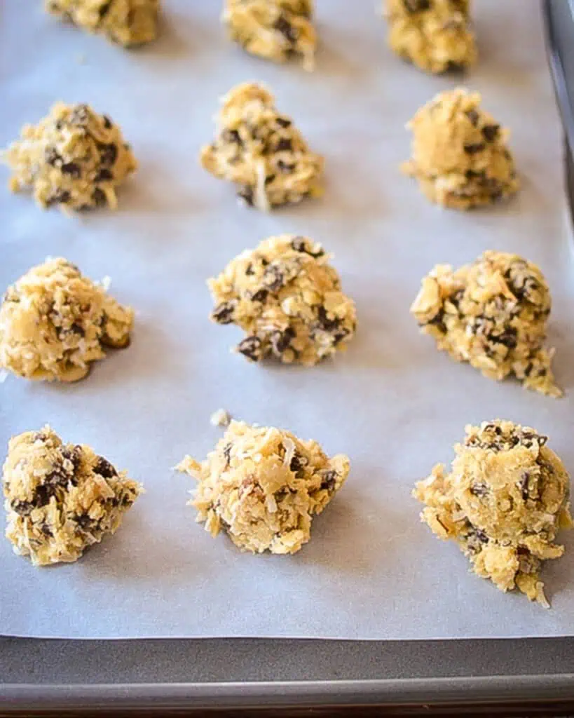 Almond joy cookie dough balls on a baking sheet covered with parchment paper. 