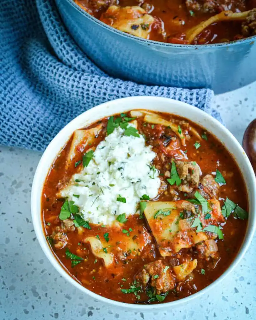 An overhead view of lasagna soup with a ricotta cheese mixture on the top. 