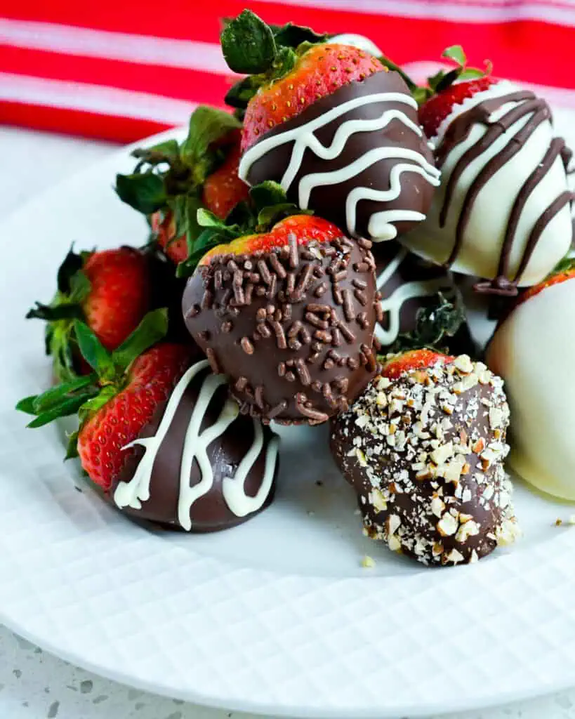 Chocolate covered strawberries stacked on a plate. 