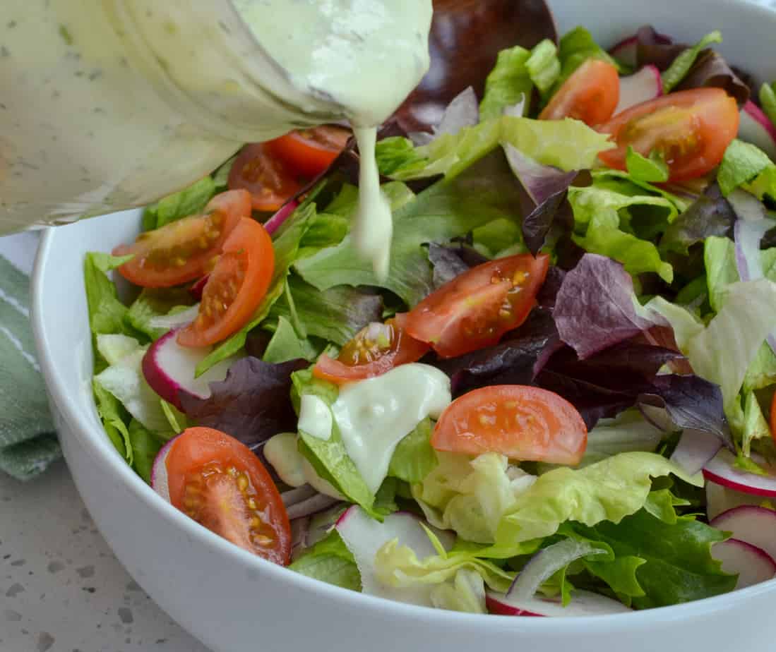 Avocado Ranch Dressing poured on a garden salad