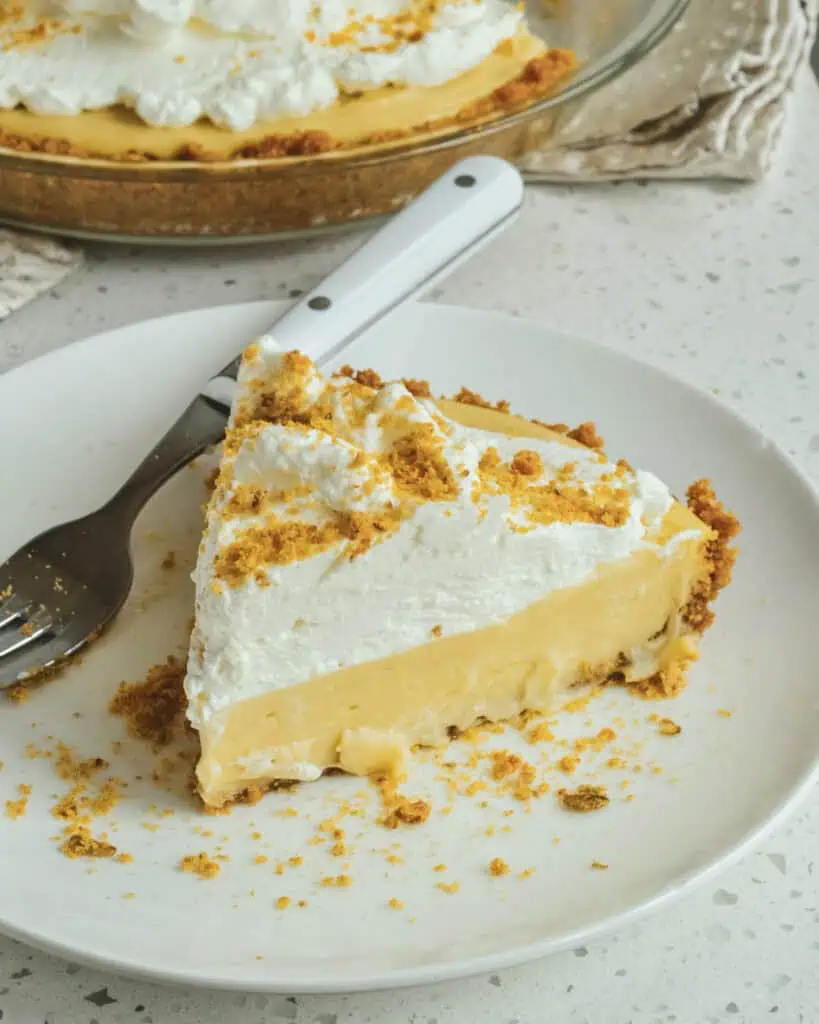 A slice of butterscotch pie on a plate with a fork. 