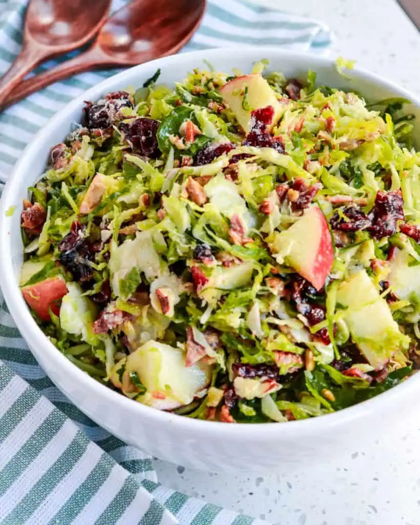 Brussels Sprout Salad is full of crisp apples, sweet pecans, dried cranberries, smoked bacon, sunflower seeds, and fresh Parmesan, all drizzled with a delicious honey mustard vinaigrette. 