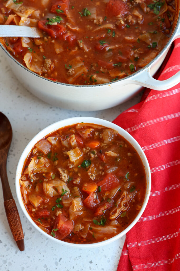 A bowl full of cabbage soup with ground beef and ground pork sausage.