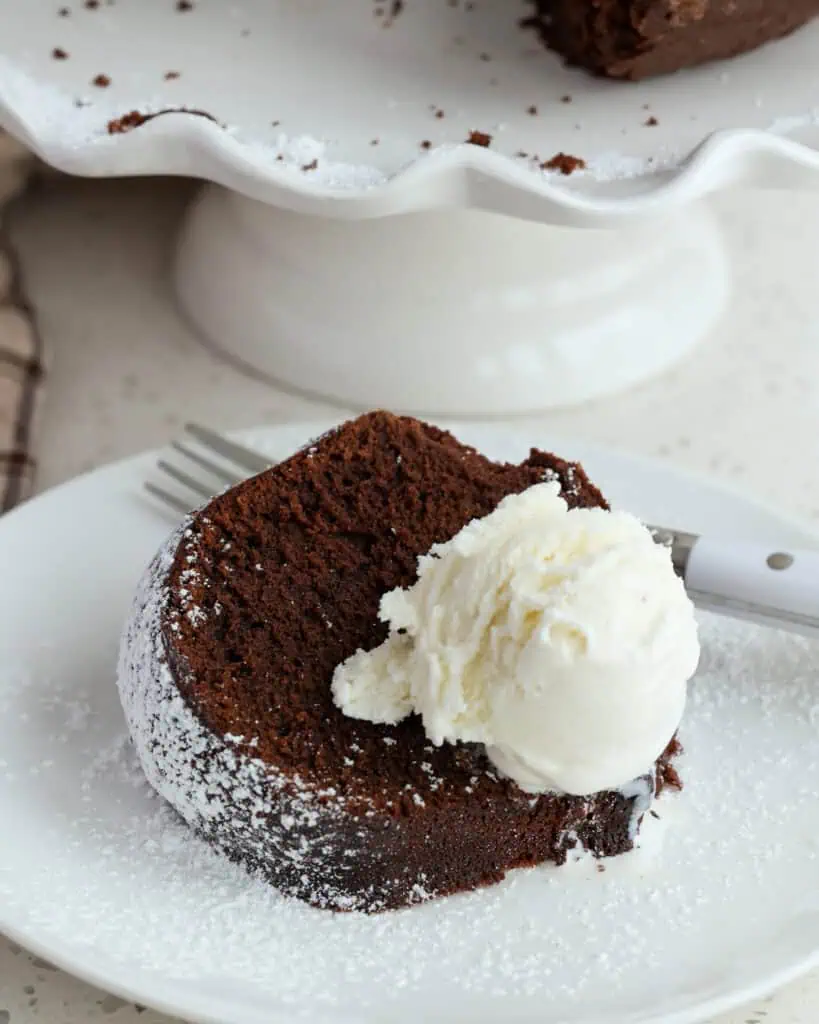 A single piece of chocolate pound cake with a scoop of vanilla ice cream. 