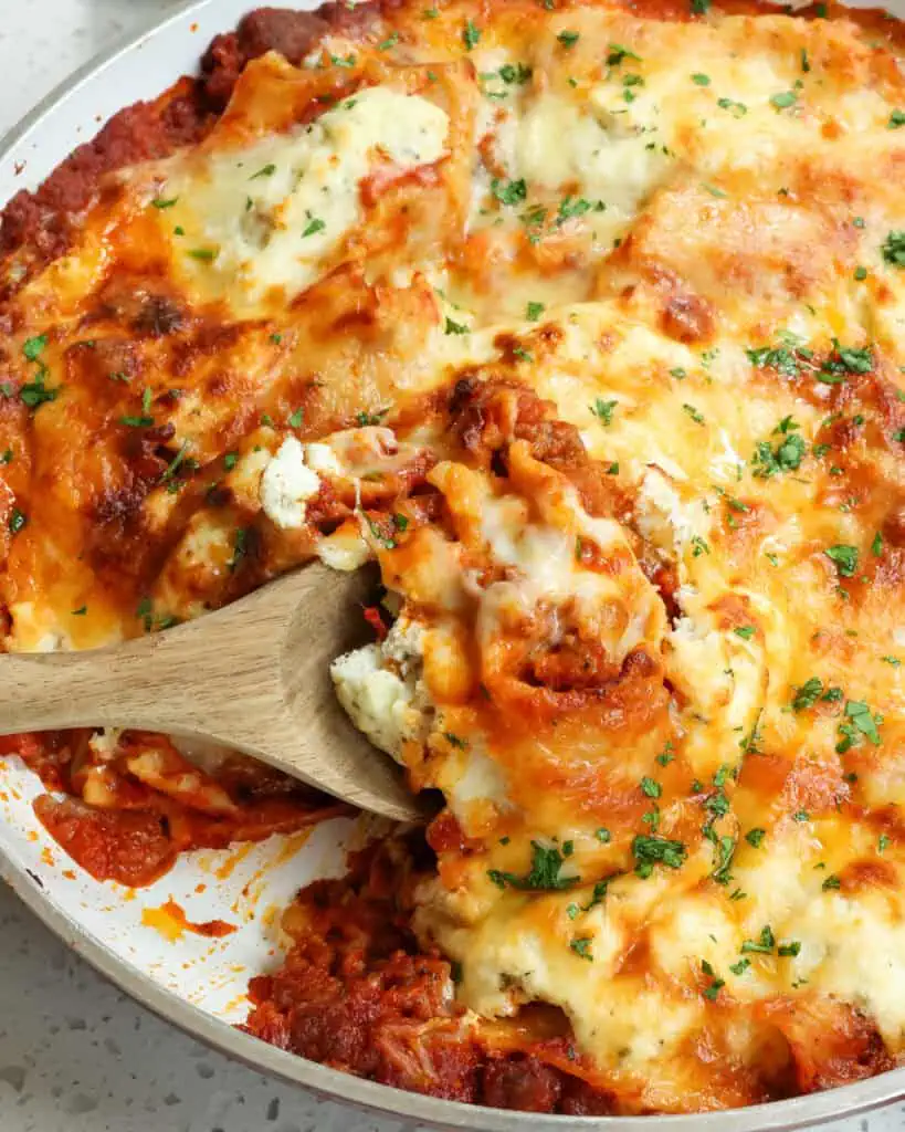 A large skillet full of lasagna with Italian sausage, ricotta cheese, and mozzarella. 