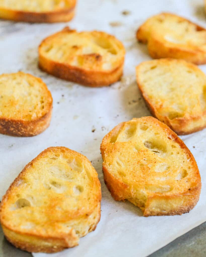 Homemade crostini on parcchment paper on a bakin sheet. 