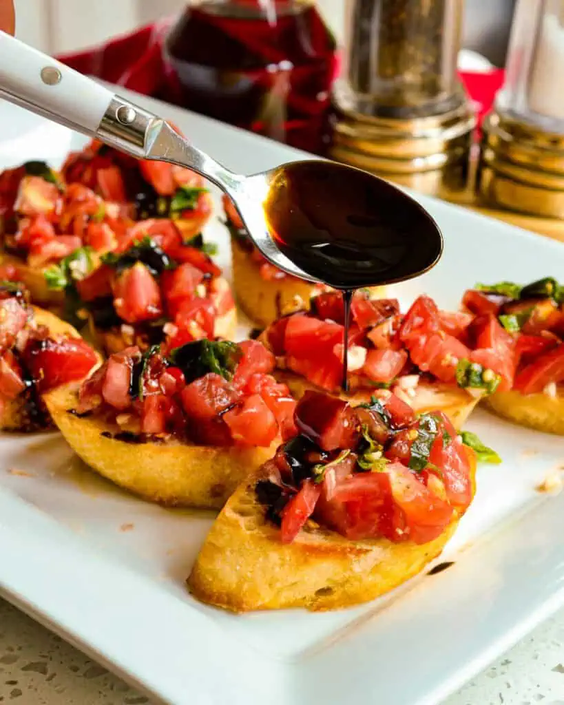 Fresh brushetta on crostini with a drizzle of balsamic glaze. 