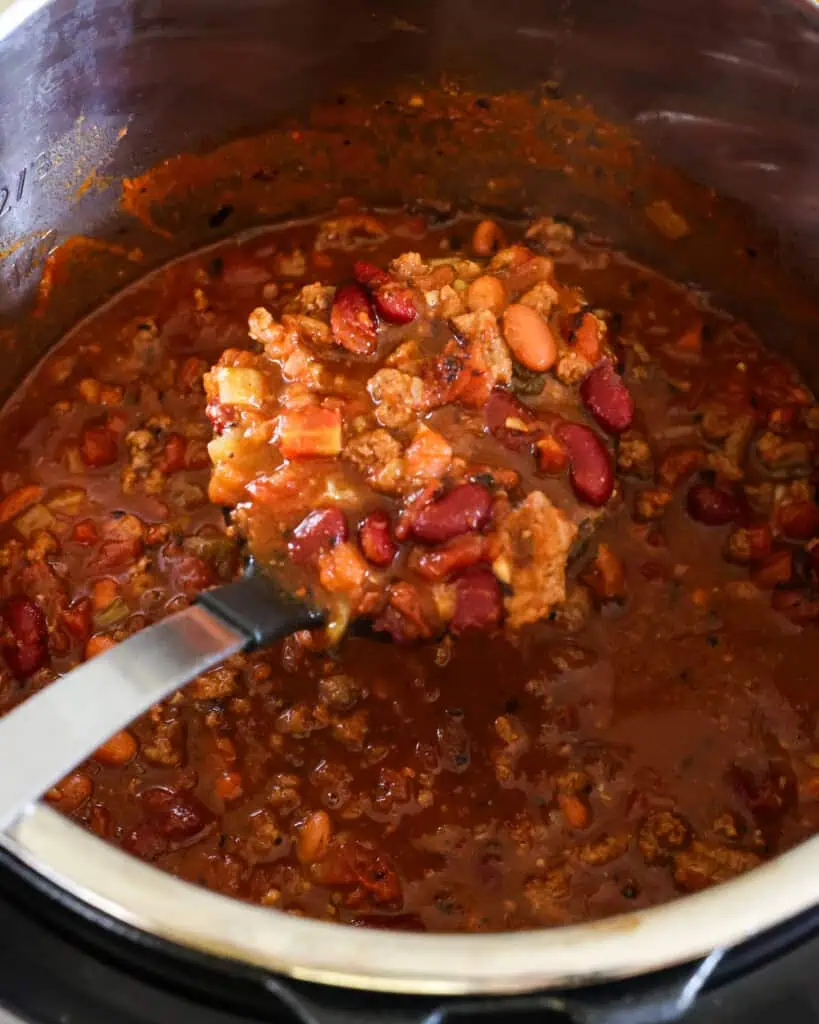 An instant pot and ladle full of chili