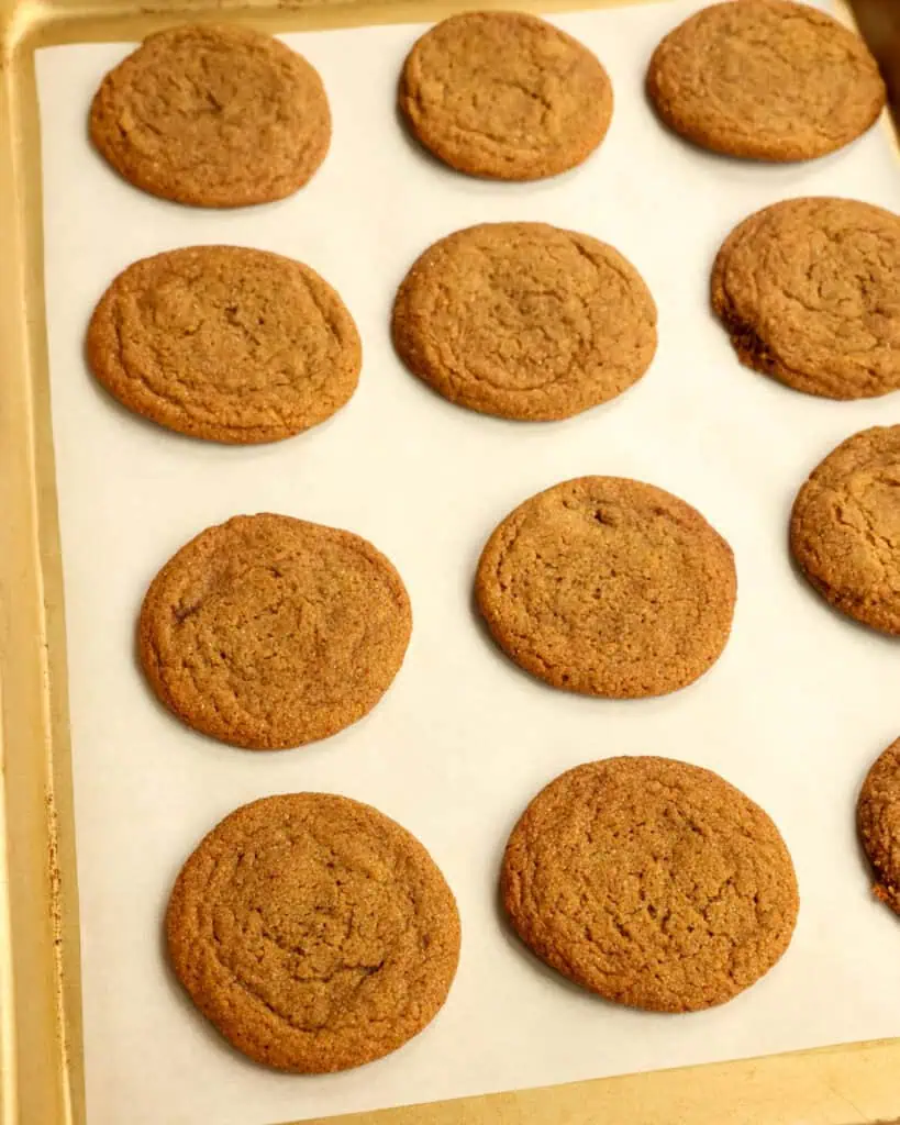 Fresh baked gingersnap cookies on a baking sheet. 