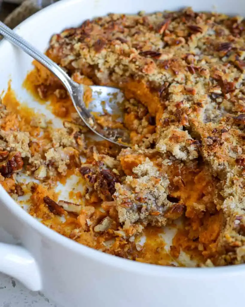 Sweet potato casserole with a metal spoon in it. 
