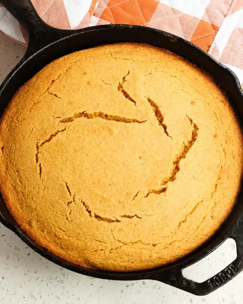 A cast iron skillet full of sweet potato cornbread. 