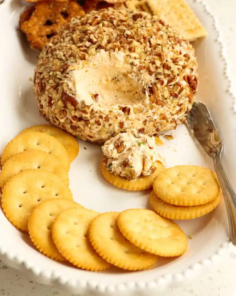 A classic cheese ball on a platter with crackers and pretzels. 