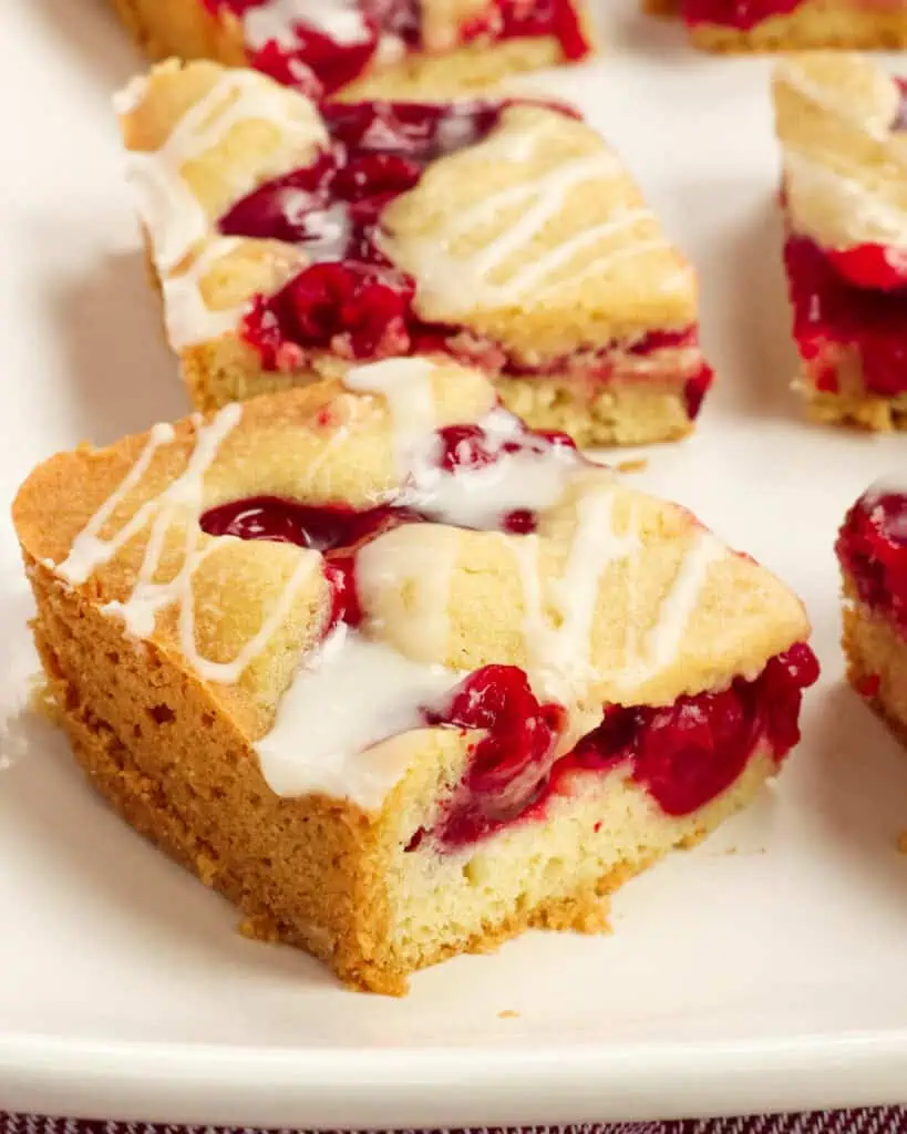 A white platter full of cherry pie bars. 