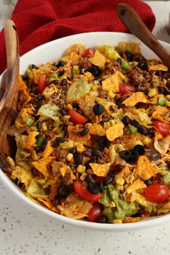 A close up view of Doritos taco salad with tomatoes, corn, and black beans. 