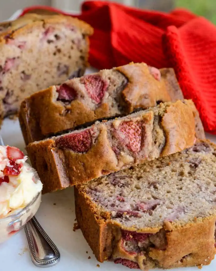 Slices of strawberry bread on a white stone cutting board. 