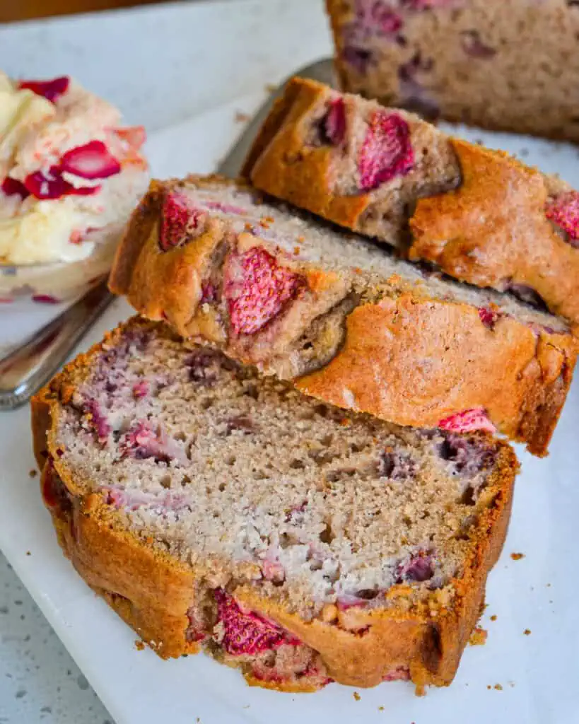 Three slices of strawberry bread with a small dish of strawberry butter on the side. 