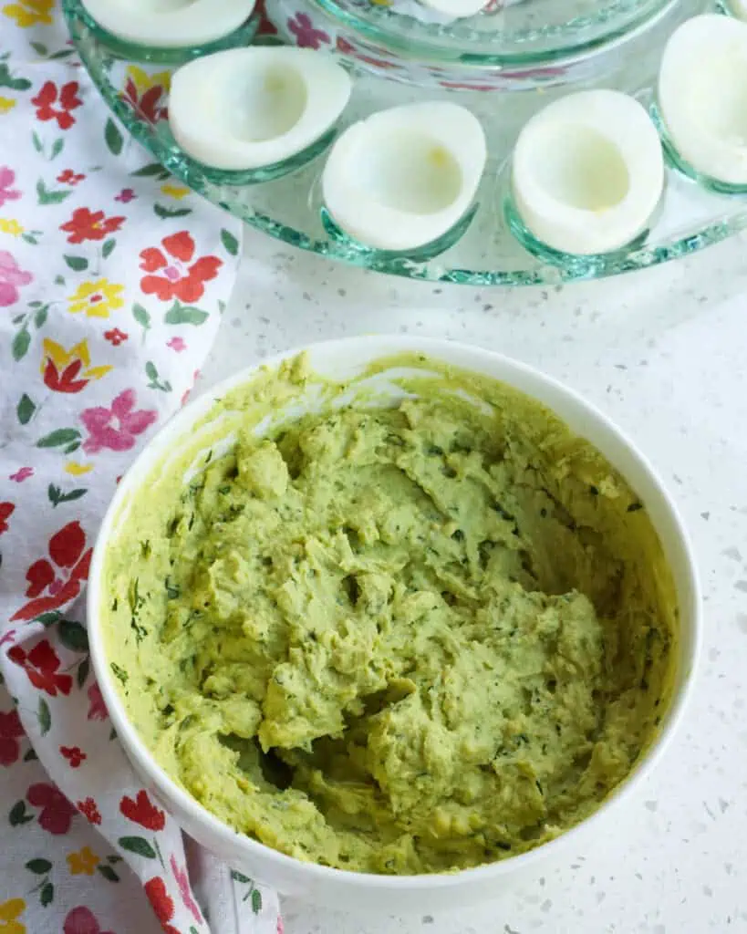 Steps to making avocado deviled eggs. Add the avocado, 5 teaspoons of chopped fresh cilantro, lime juice, garlic powder, and cayenne pepper. Mash everything well with a fork and season with kosher salt and fresh ground black pepper to taste.