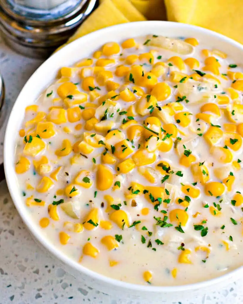 An overhead view of creamed corn with chopped chives. 