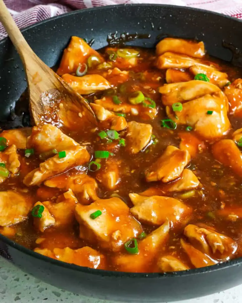 Bourbon chicken simmering in a skillet 