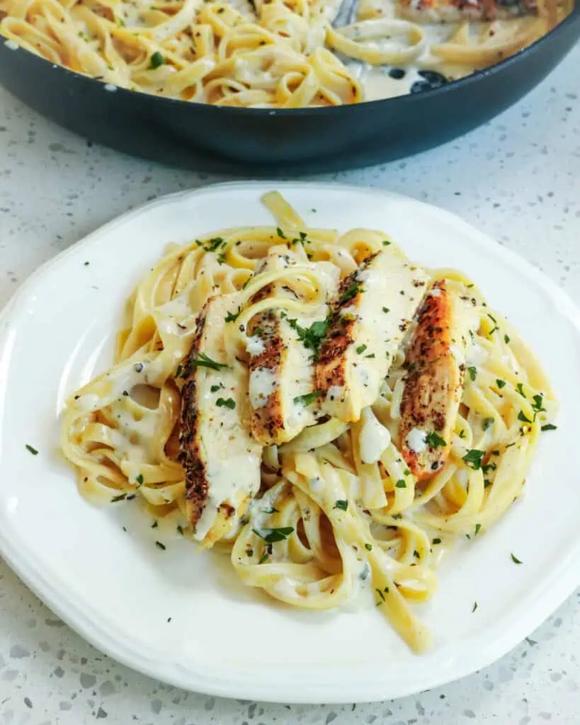 A single serving plate ful of chicken alfredo 