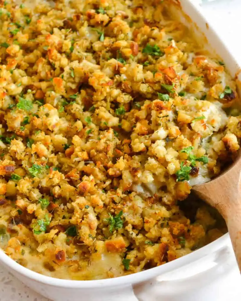 Chicken Stuffing Casserole with a wooden spoon in it. 