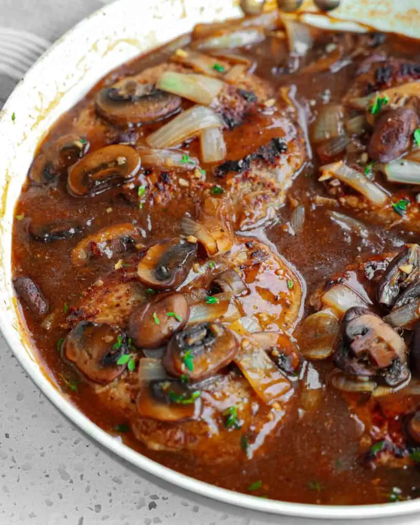 Browned cube steaks in brown gravy with mushrooms and onions. 