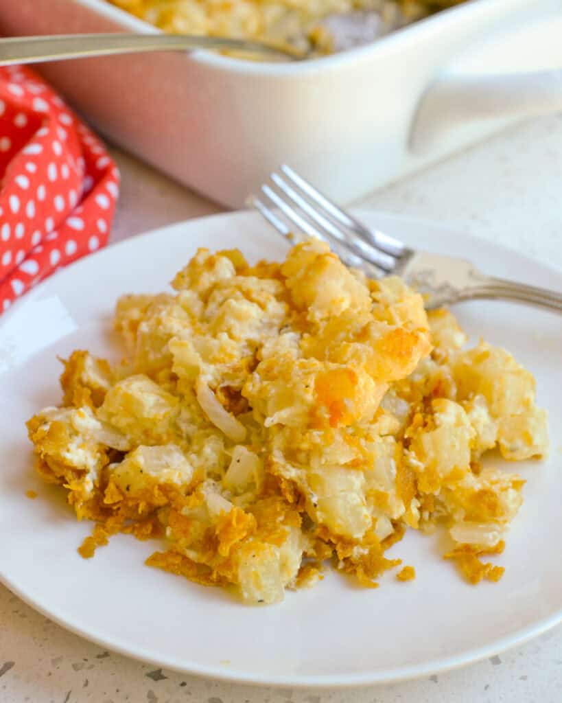 A single serving plate full of cheesy hashbrown potatoes. 