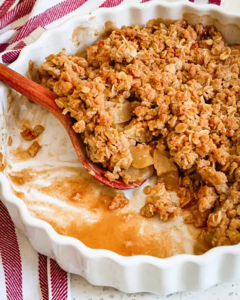 Apple crisp in a baking with a wooden spoon. 