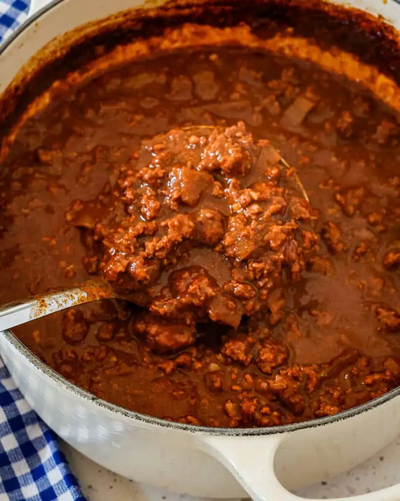 A big dutch oven and ladle full of Cincinnati chili, 