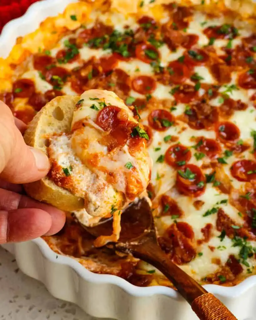 Pizza dip scooped on a crostini. 