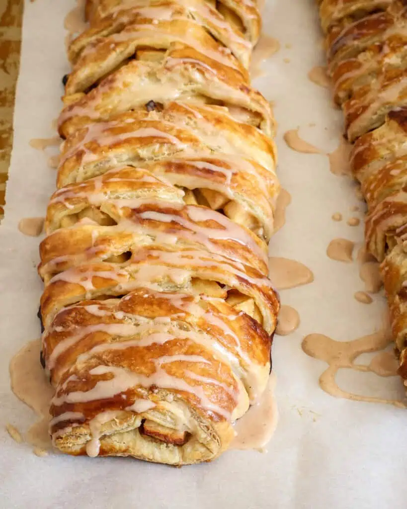 Glazed apple strudel on parchment paper. 