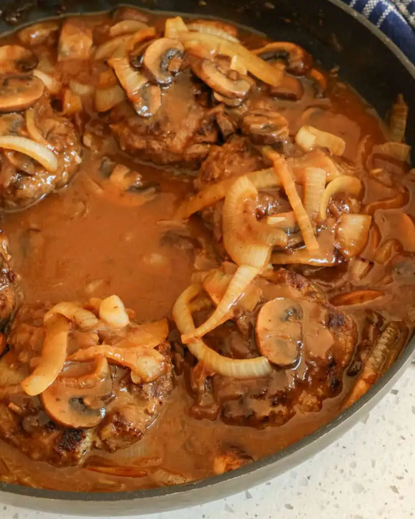 Smothered hamburger steaks in a large skillet. 