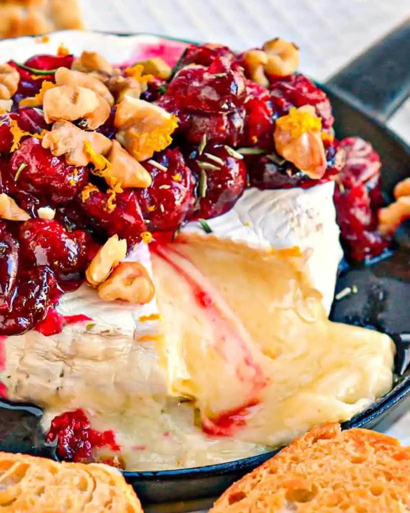 Baked brie topped with cranberries, walnuts, orange zest and rosemary. 