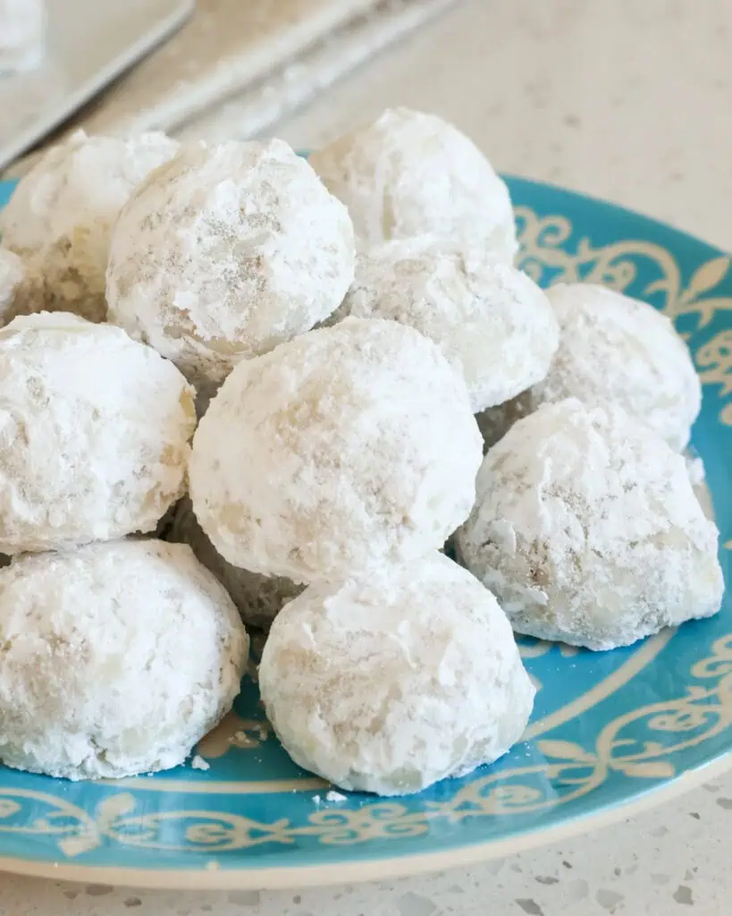 Snowball cookies stacked on a plate. 