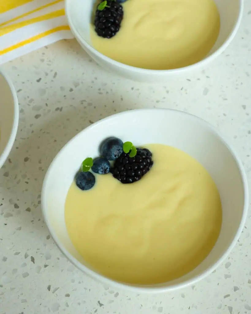 A close up view of vanillla custard with fresh berries. 