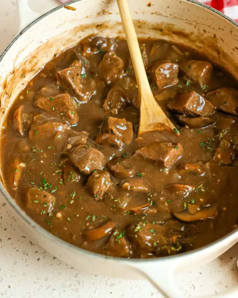 A Dutch oven full of beef tips and gravy. 