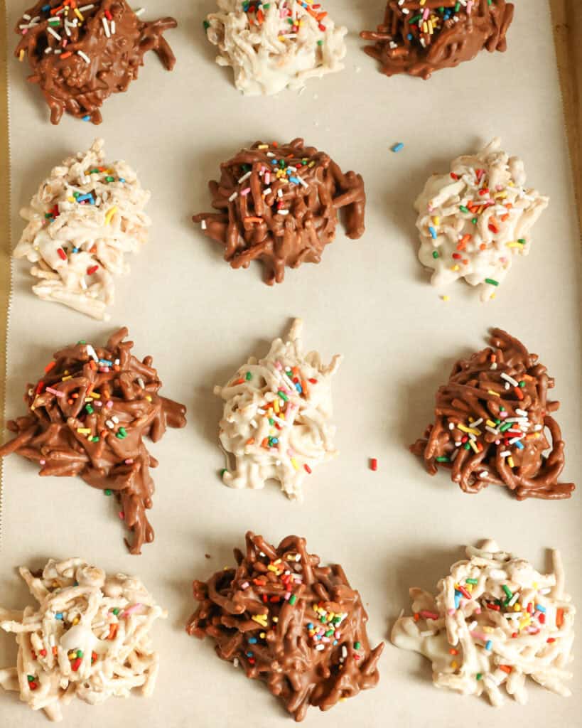 Chocolate and white chocolate haystacks on a baking sheet covered with parchment paper. 