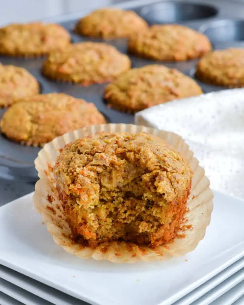 The inside of a bran muffin with the pan of bran muffins in the background. 