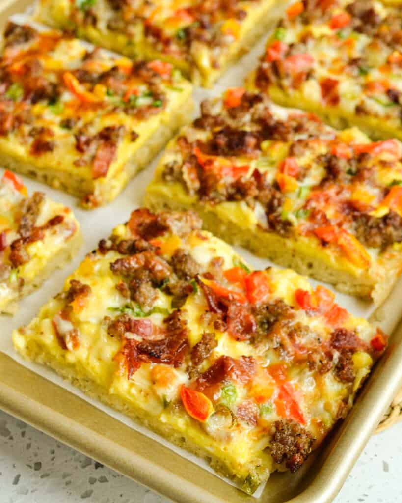 Fresh baked breakfast pizza on a parchment paper covered baking sheet. 