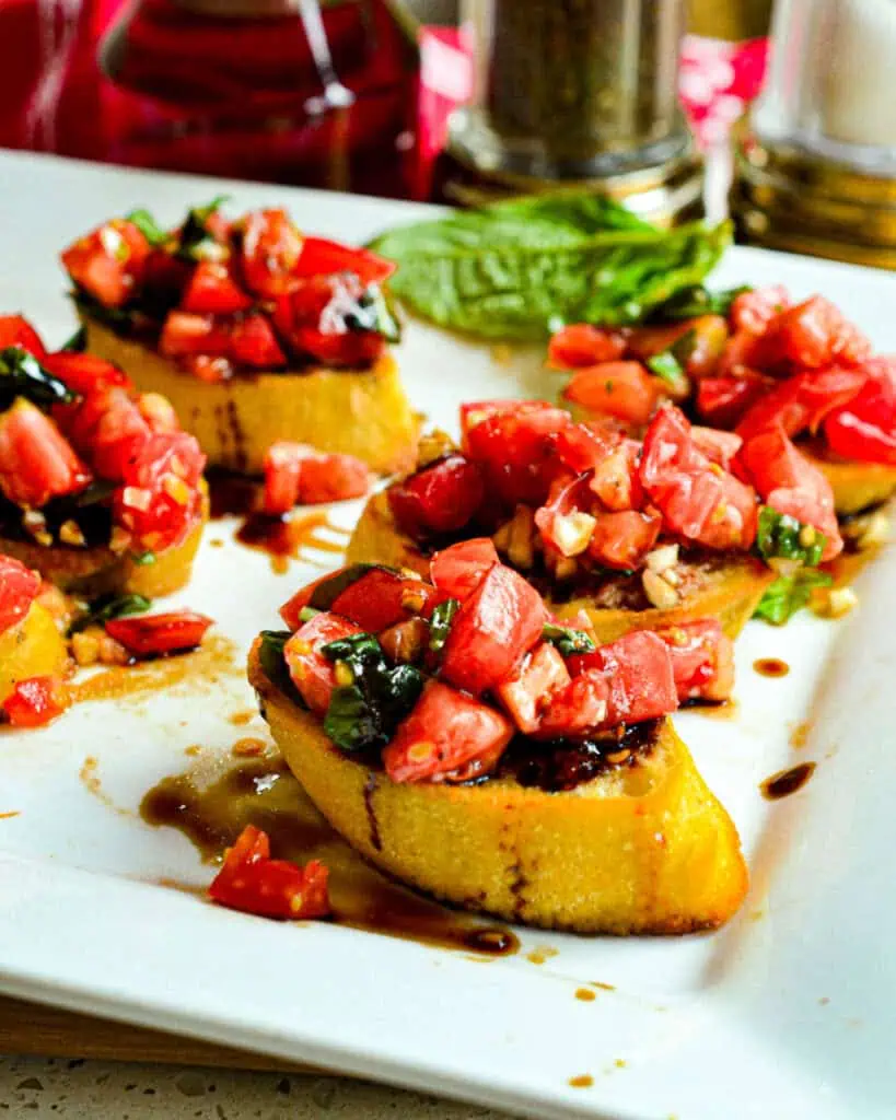 An easy garden-fresh bruschetta recipe combining sun-ripened tomatoes, sweet basil, and garlic, all served on toasted baguette slices with a drizzle of balsamic glaze. 