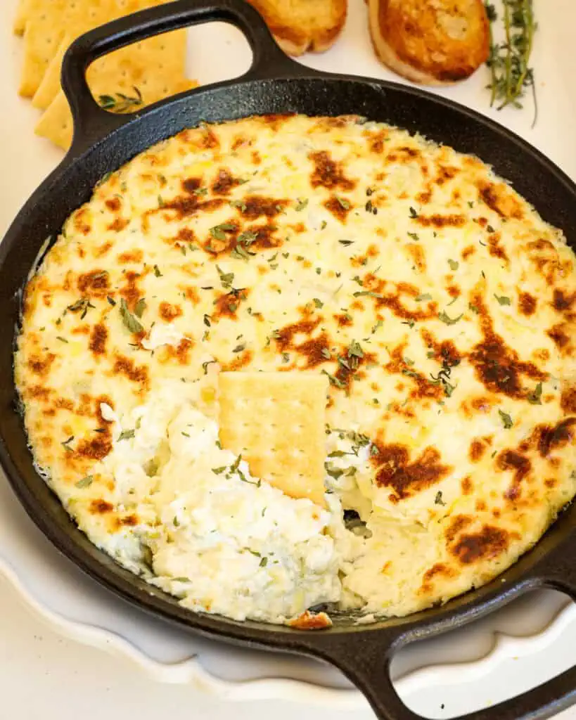 A skillet full of hot artichoke dip. 