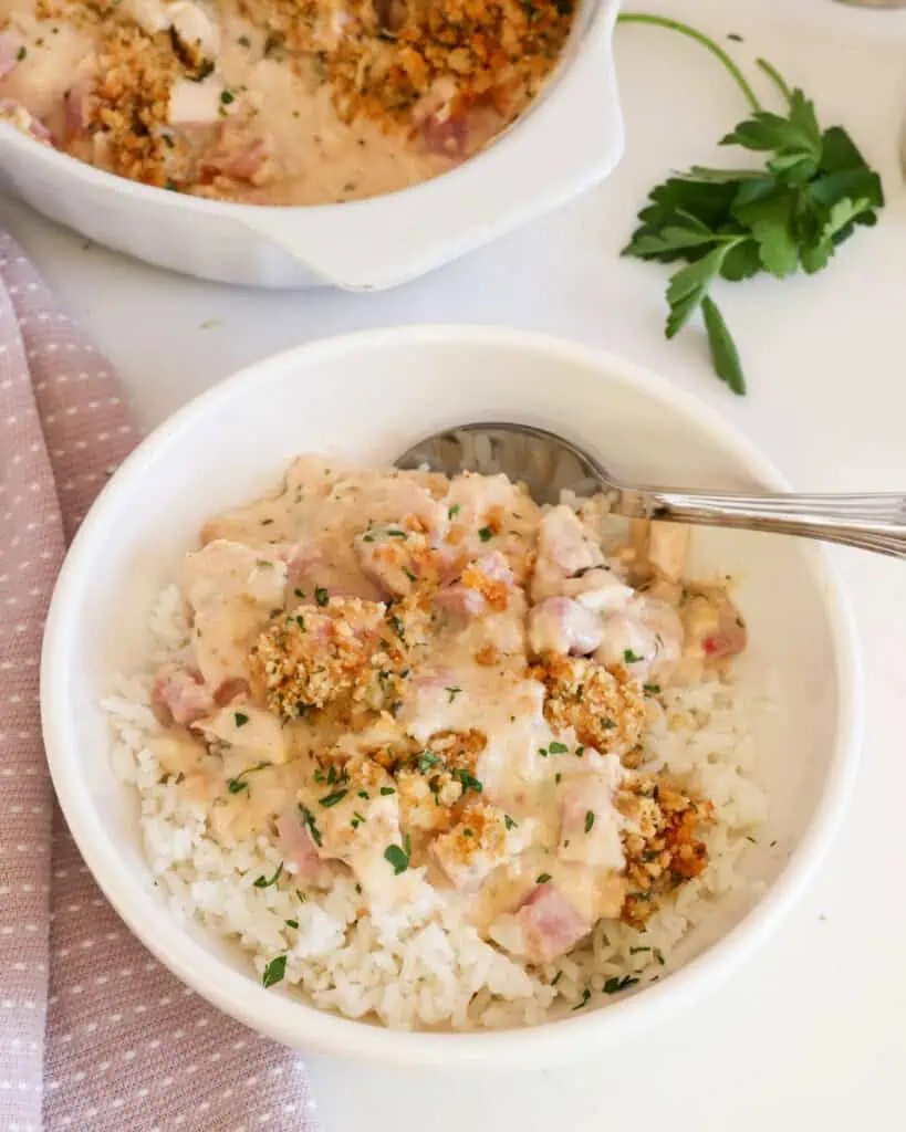 A single serving bowl full of chicken cordon blue casserole over white rice. 