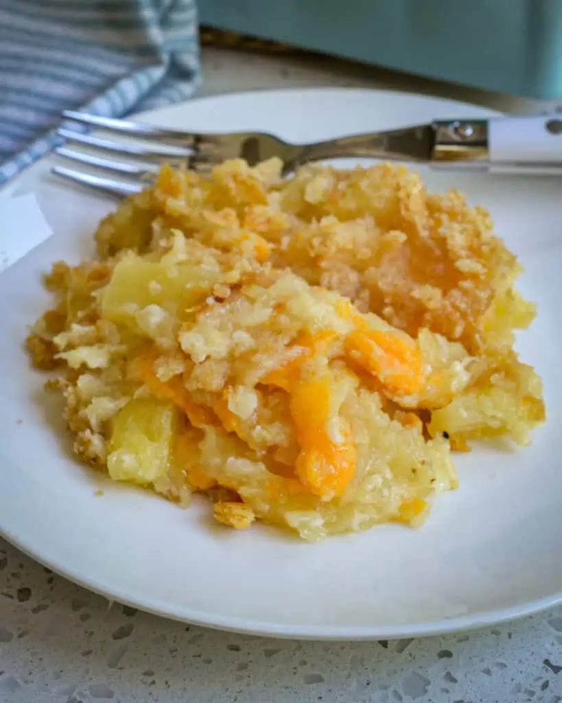 Pineapple casserole on a single serving plate with a fork. 