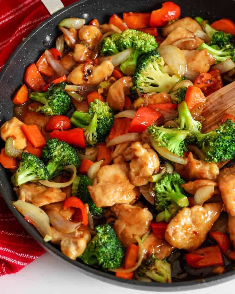 Hunan chicken is a classic Chinese stir-fry with thinly sliced chicken breasts, celery, broccoli, red bell pepper, and carrots in a savory garlic ginger sauce. 