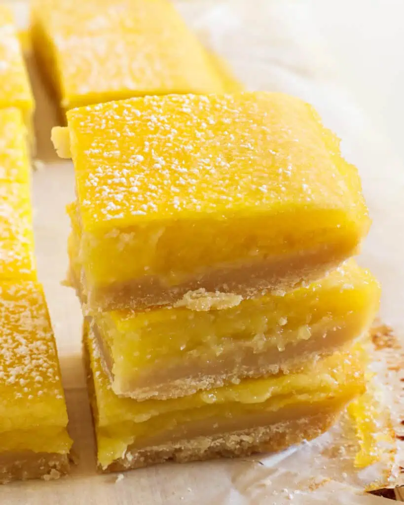 A stack of lemon bars with powdered sugar dusted over the tops. 